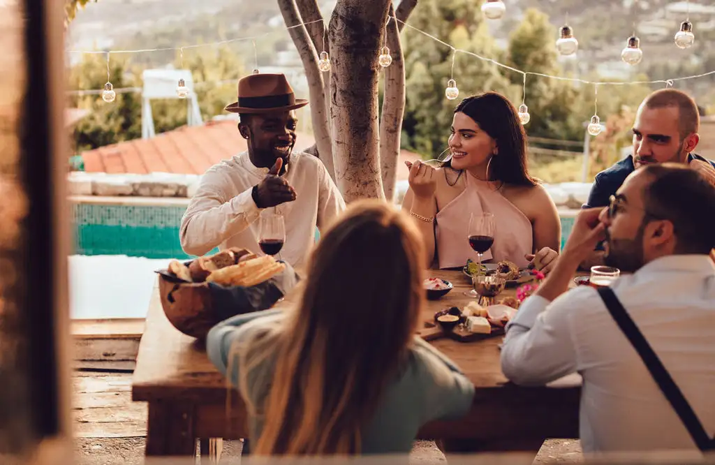 Group of millenial travelers enjoying a meal