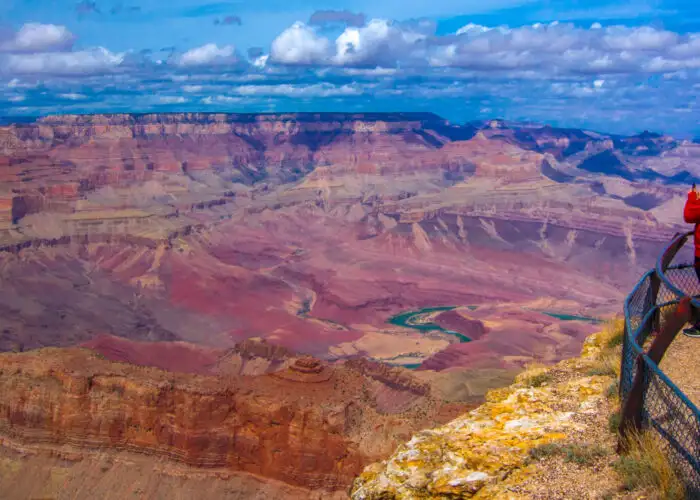 Three people admiring the vista at a Grand Canyon lookout point