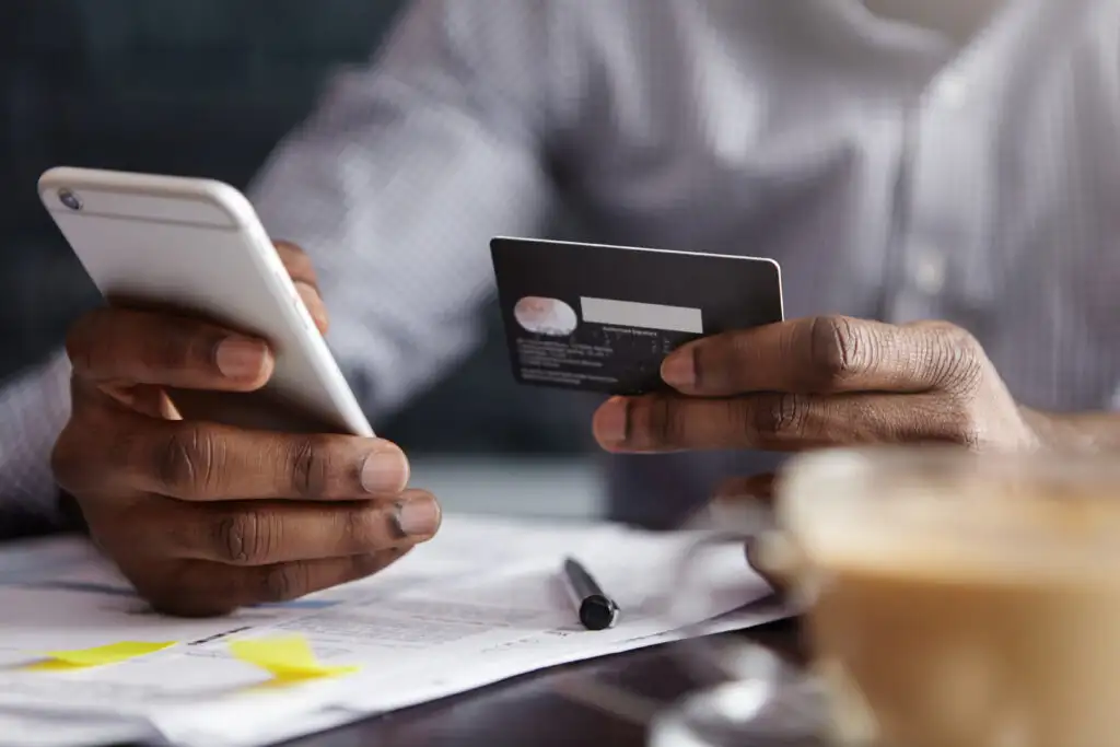 Close up of man making a credit card purchase no his phone