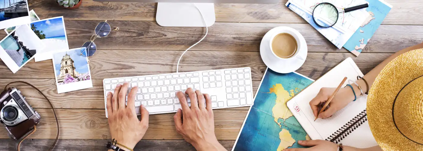 Two people booking travel on a computer