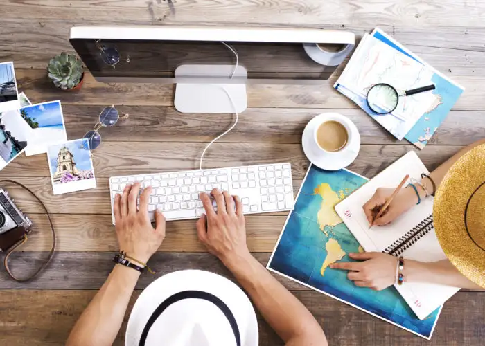 Two people booking travel on a computer