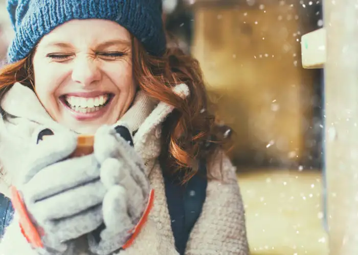 Women wearing winter gear and holding a hot drink