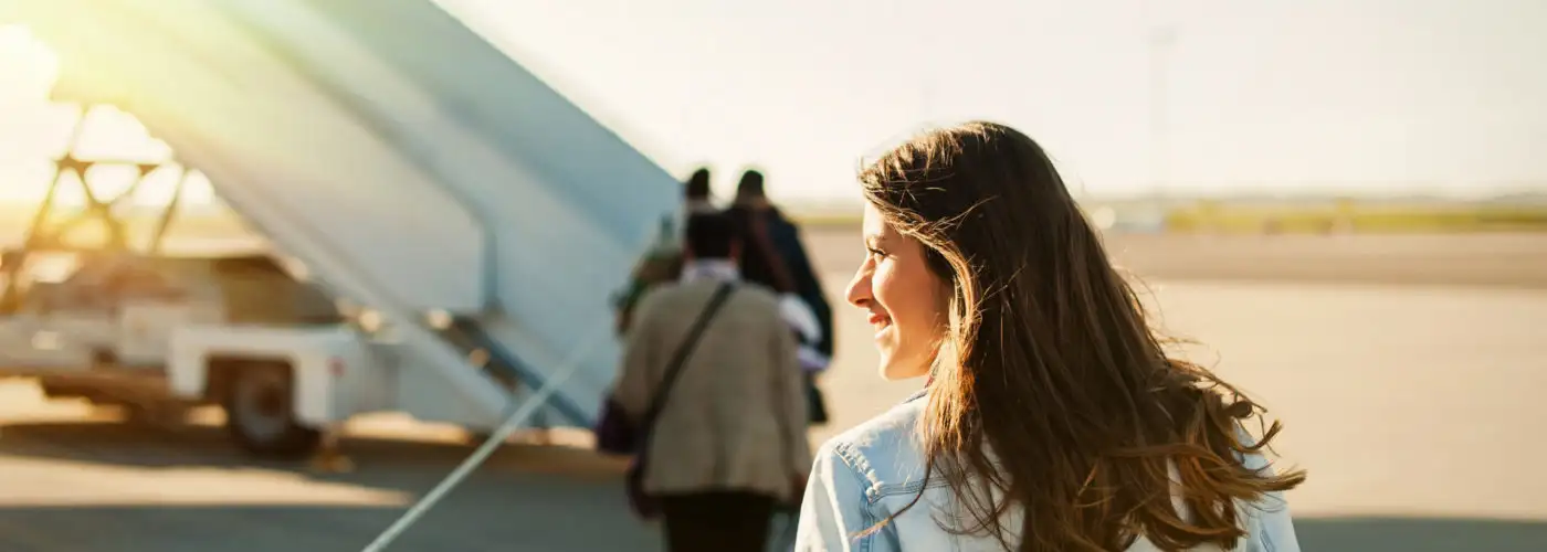 Woman walking towards a plane on the tarmac to board