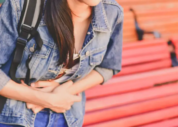 Woman having stomach pain at a train station