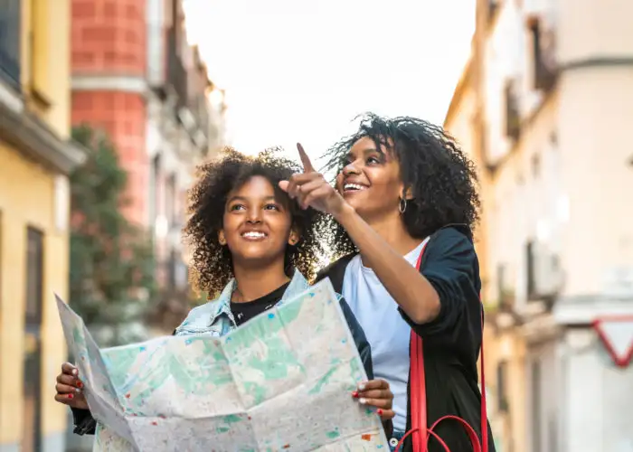 Mother and daughter navigate city using paper map