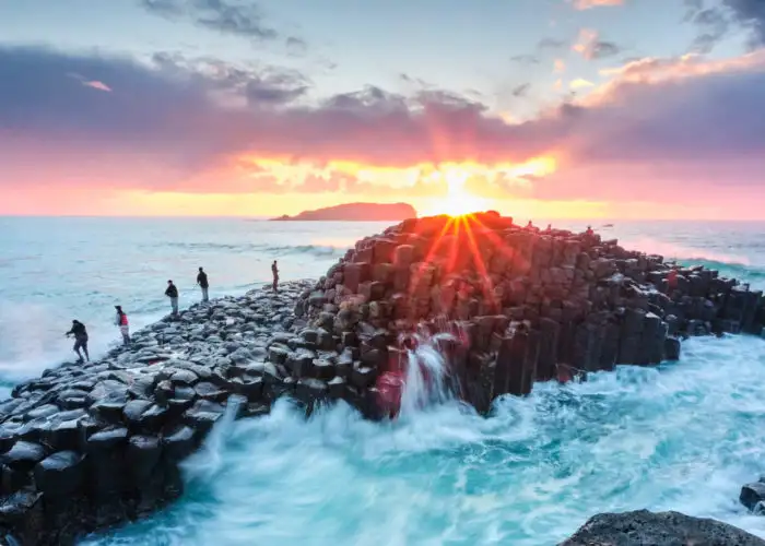 Fisherman on Giant's Causeway at sunrise in Ireland