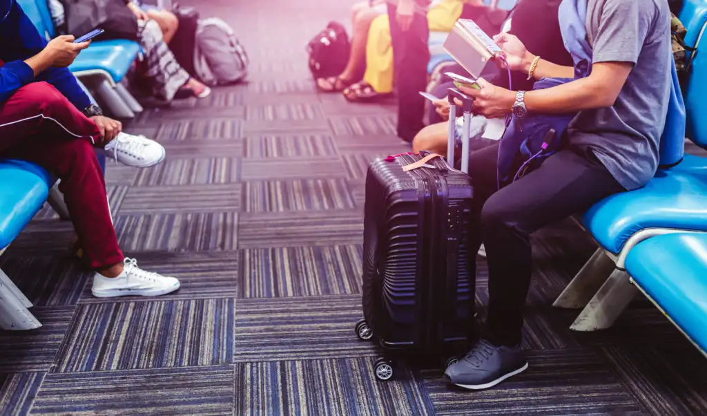 People waiting to board a plane with their luggage