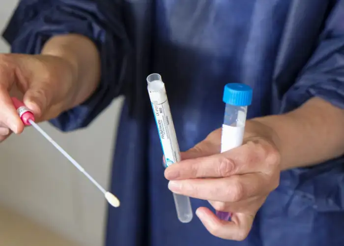 Woman holding a self-PCR COVID-19 test