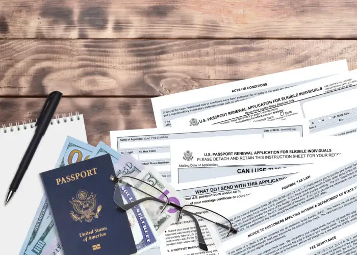 Passport renewal application on table with passport, glasses, and money