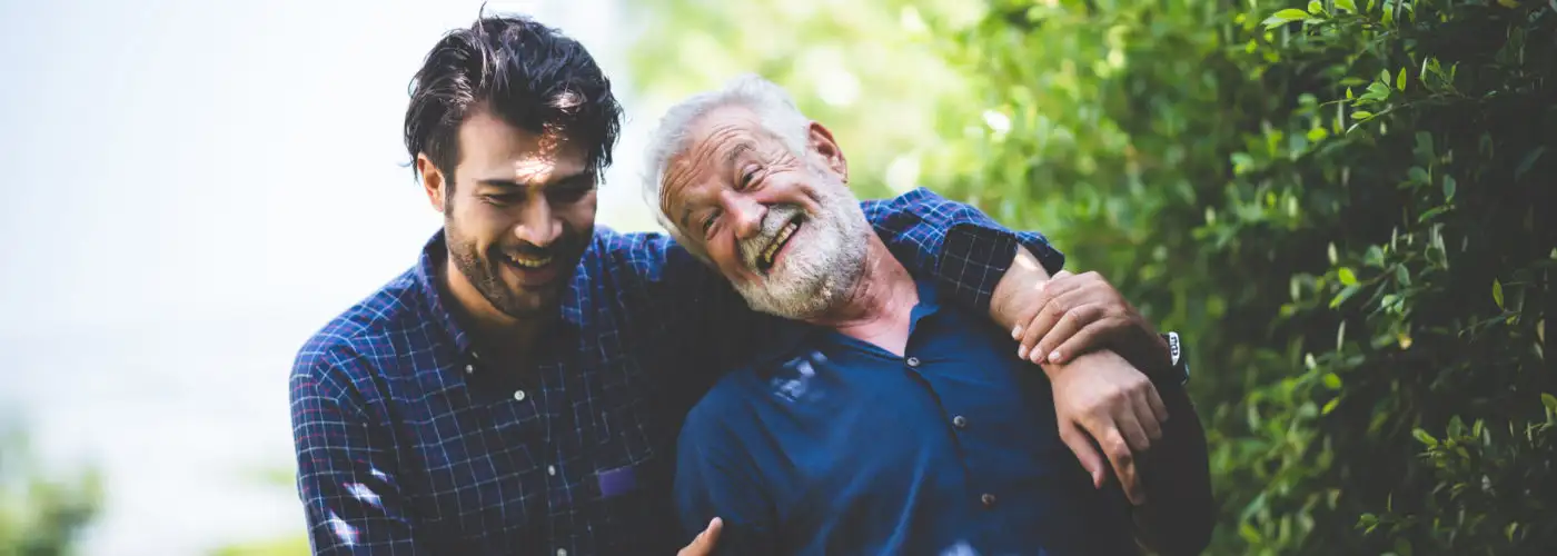 Father and son walking together down a green outdoor path