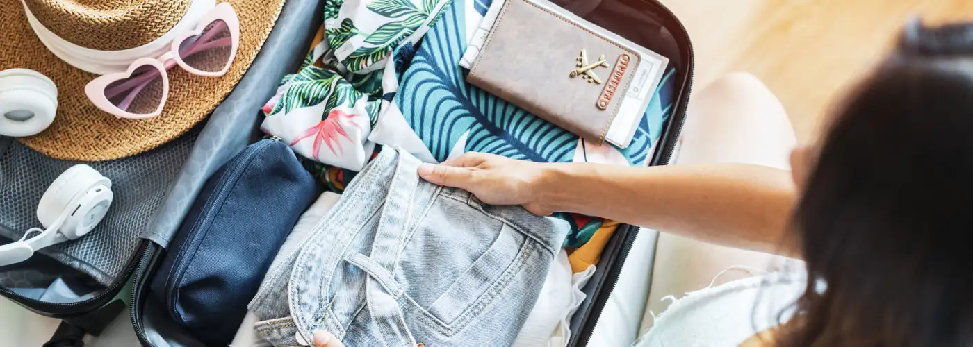 Overhead view of woman packing a suitcase