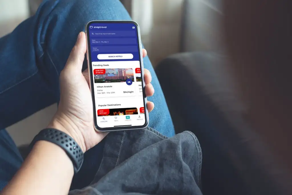 A man holding a phone showing the booking app Snaptravel