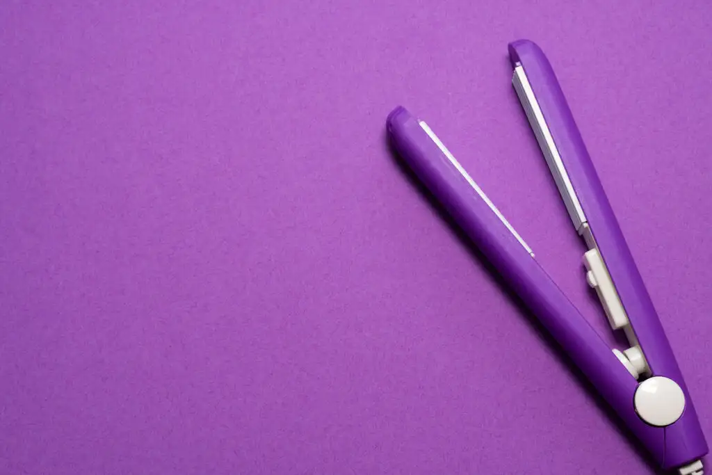 Purple hair straightener on a purple backdrop