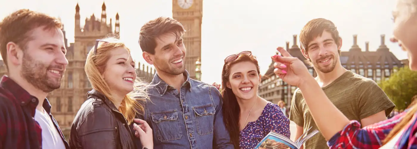 Group of friends talking over a map in front of Big Ben in London