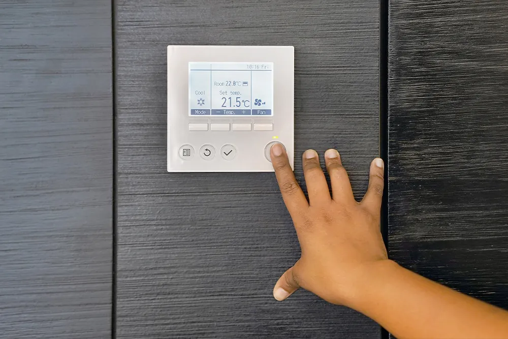 African woman hand try to turn on the new air condition in room, in the hotel room. African female hands on the air conditioning control panel. Hand girl setting temperature air condition.