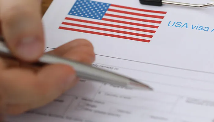 Man with passport and dollars points with pen at documents in folder of embassy closeup. Assistance in obtaining american visas concept.