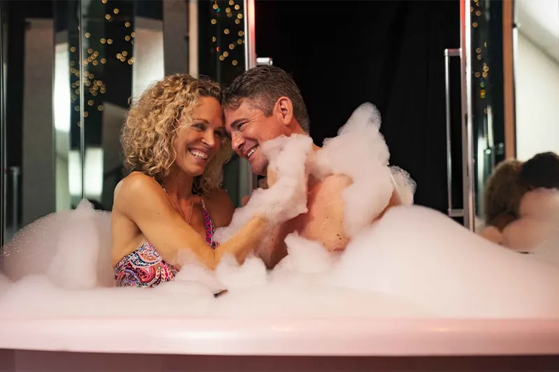 A couple bathing in the Champagne Tower jacuzzi at Cove Haven Resort, Pennsylvania