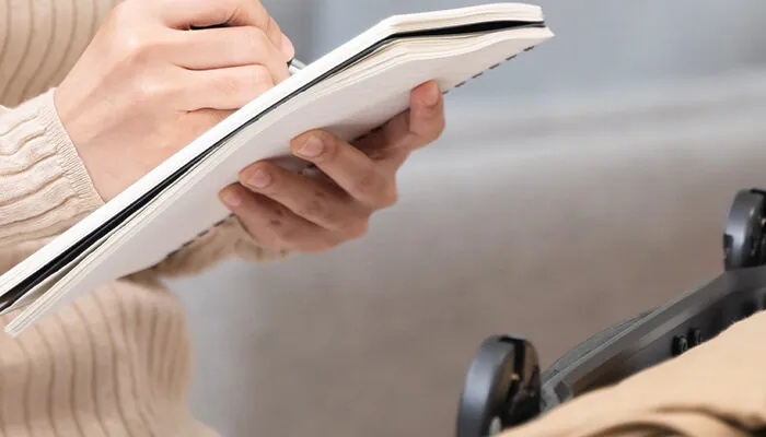 Woman packing suitcase using checklist