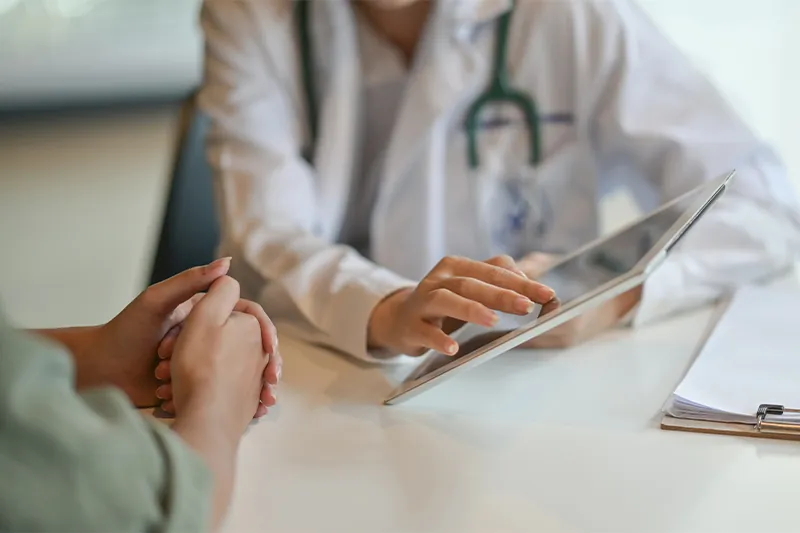 Patient sitting across the desk from a doctor