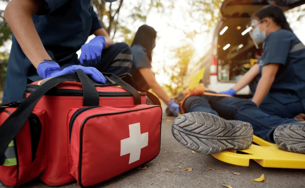 Emergency Medical First aid kit bags in front of first aid team assisting unwell person