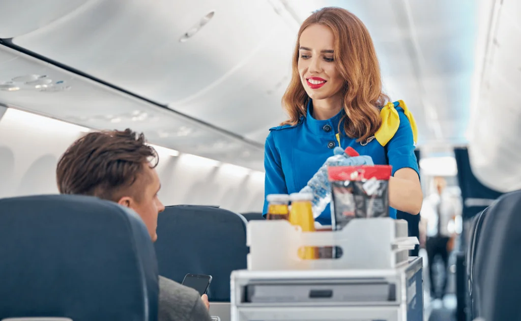 Flight attendant serving food and drinks to passengers on board