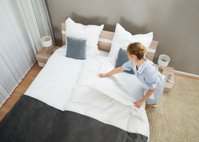 hotel housekeeper making a bed.