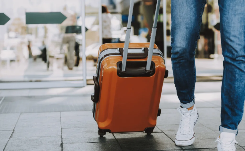 Male is carrying luggage in hall before trip