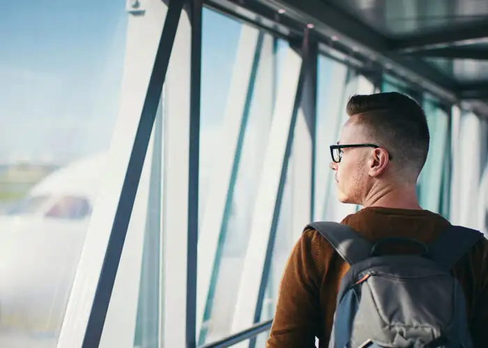 man looking out airport window.