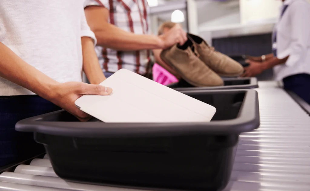 Man Puts Digital Tablet Into Tray For Airport Security Check