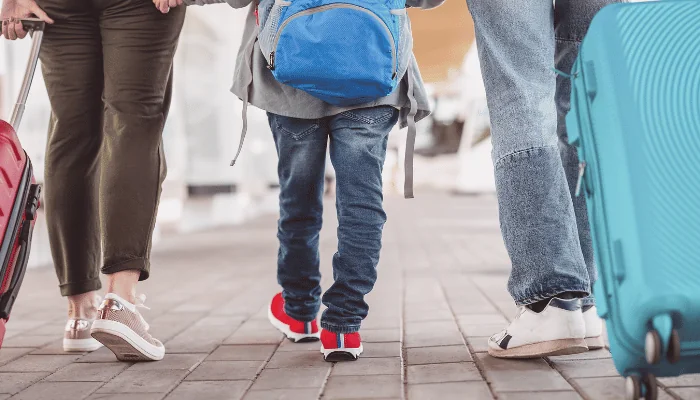 Family walking at airport with luggage