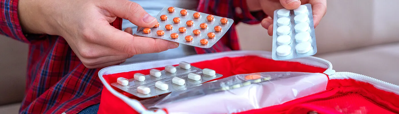 Person packing medication for travel