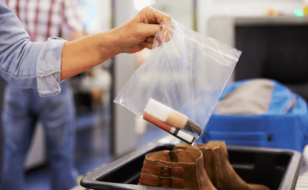 Passenger Puts Liquids Into Bag At Airport Security Check