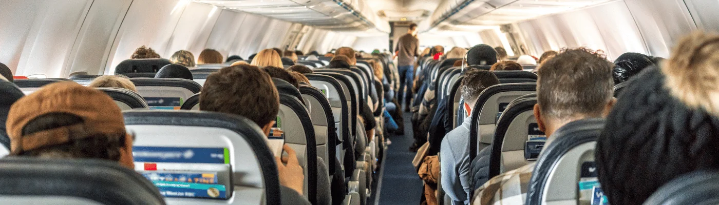 Passengers seated inside of a commercial passenger airplane. Travelers going across the globe.