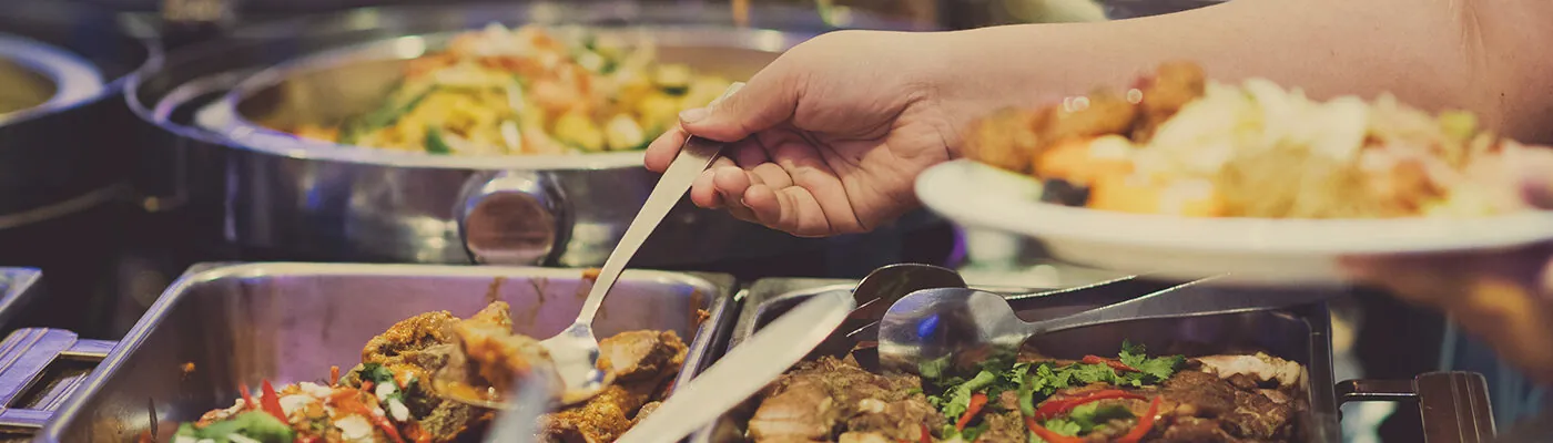 Close up of person serving themselves at a buffet