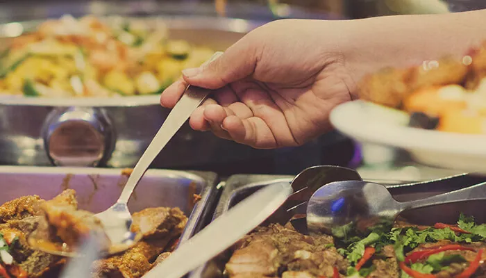 Close up of person serving themselves at a buffet