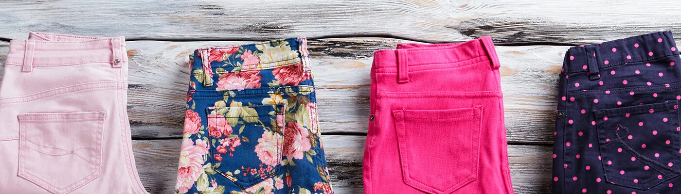 Row of pants folded on wooden background