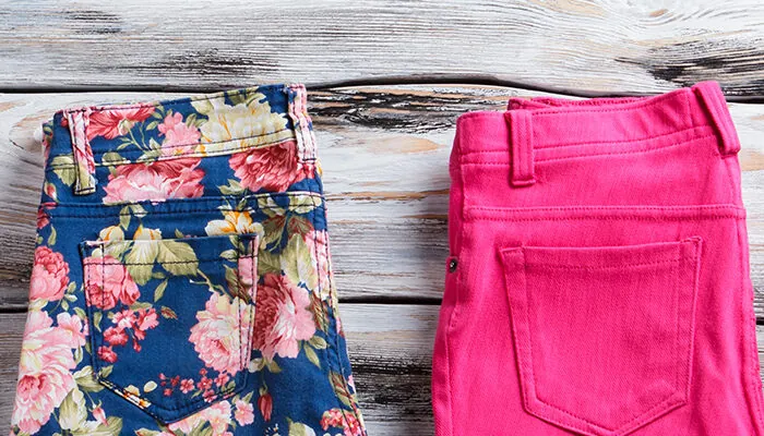 Row of pants folded on wooden background