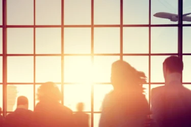 Silhouettes of people in a crowded airport at sunset