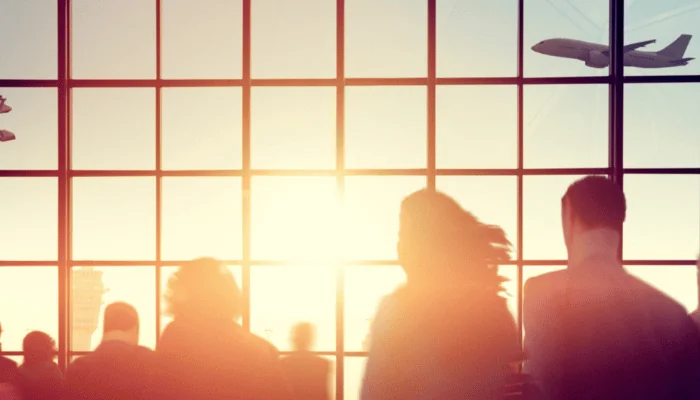 Silhouettes of people in a crowded airport at sunset