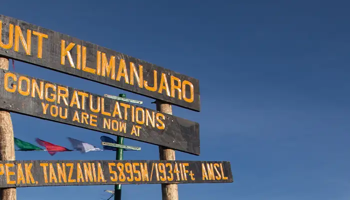 Sign at summit of Mount Kilimanjaro congratulating hikers for reaching the top