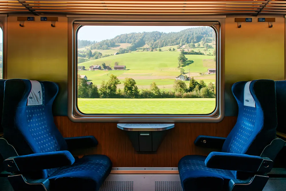 Swiss rural farmland through train window, Train travel concept.