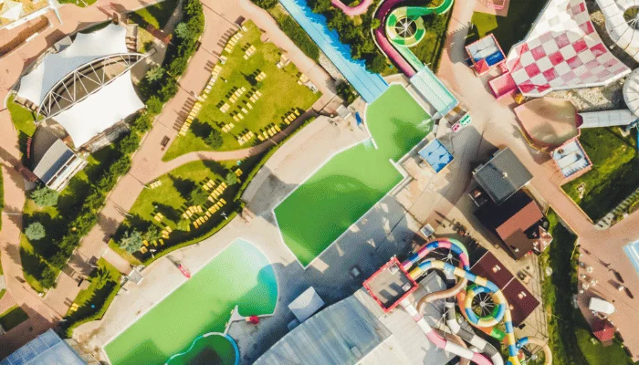 Colourful plastic slides in aquapark. Sliders with pool. Enjoying summer vacation in water park. Aerial view of aqua park.