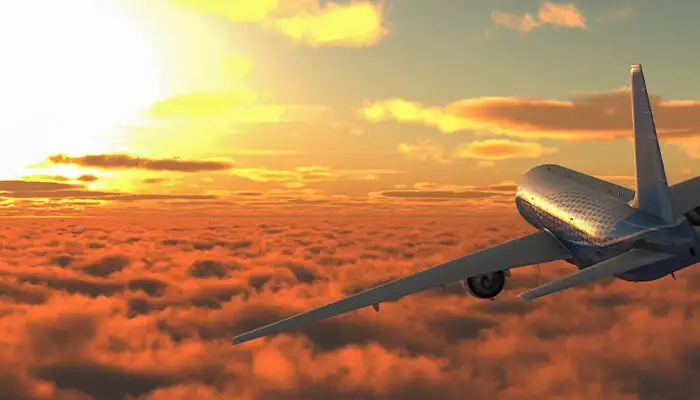 passenger plane flying into the sunset