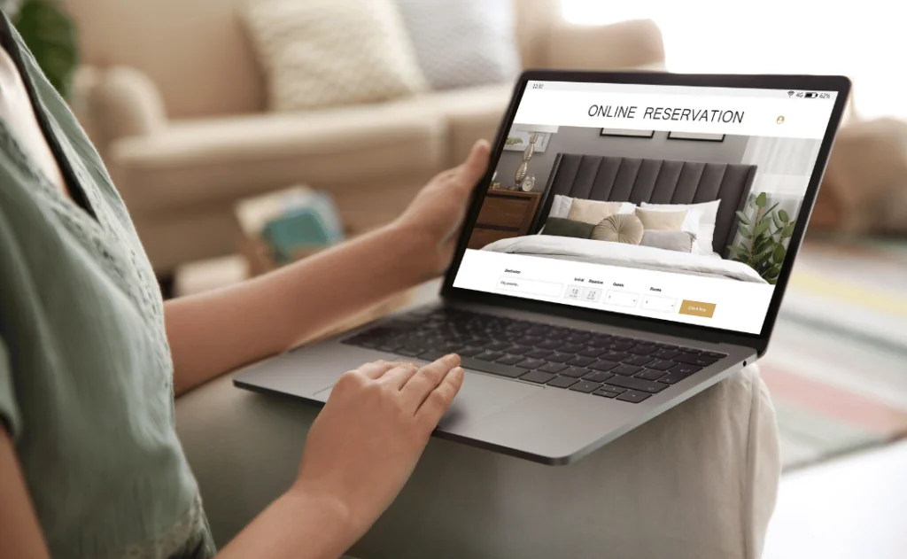 Closeup of a woman using laptop to book hotel stay.