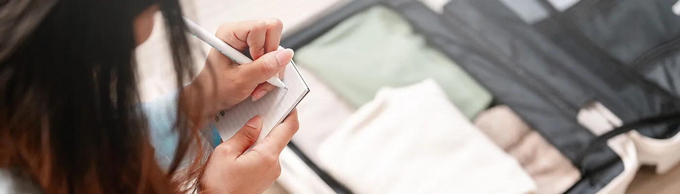 Woman using packing list to pack for her trip.